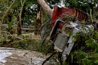 A large truck is impaled onto a tree after flash flooding on the bank Guadalupe River on July 5, 2025 in Center Point, Texas